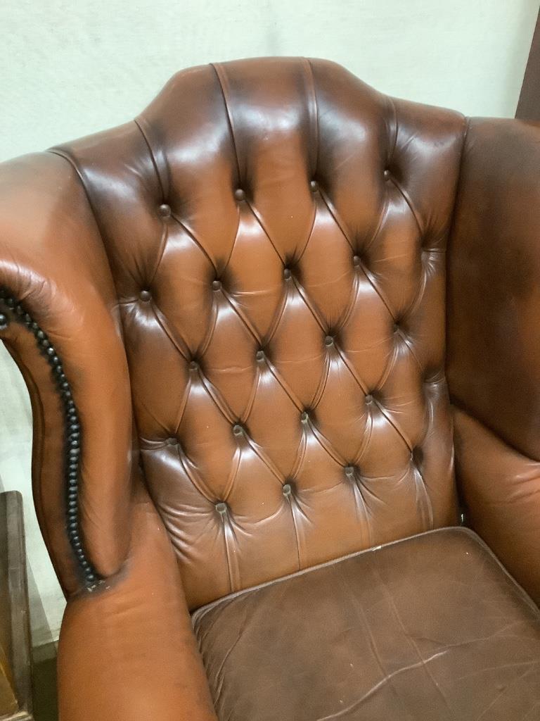 A buttoned burgundy leather wing armchair, width 86cm, depth 80cm, height 110cm